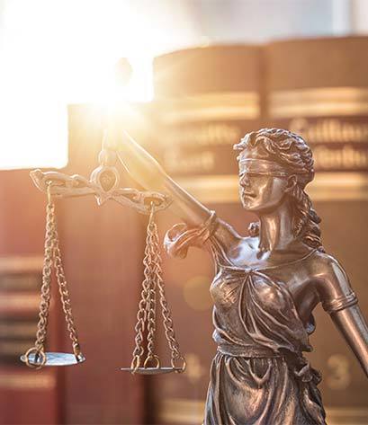 Lady Justice with business litigation books in the background at a Los Angeles attorney's office